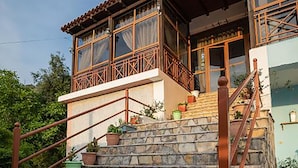 A stone staircase leading to a wooden balcony with railings. - Hotel Panorama (Himarë)