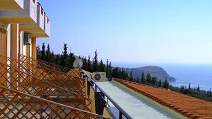 A hotel with a balcony overlooking a coastal landscape, featuring a clear view of the sea and distant hills. - Hotel Panorama (Himarë)