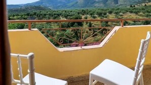 A balcony with two white chairs and a table, overlooking a mountainous landscape. - Hotel Panorama (Himarë)
