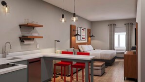 Una habitación de hotel moderna con kitchenette, una cama, una zona de estar y un televisor.