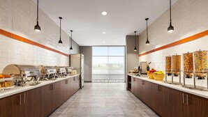 Una cocina moderna con una encimera larga, equipada con electrodomésticos y dispensadores de alimentos.