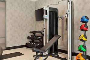 Work out in style with a fully equipped gym featuring a bench press, dumbbells, and medicine balls.