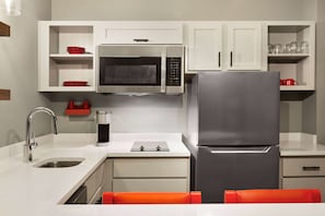 Prepare meals in this kitchen with stainless steel appliances, a sink, and a coffee maker.