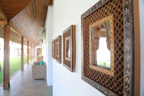 Un pasillo con vigas de madera y obras de arte enmarcadas en las paredes.