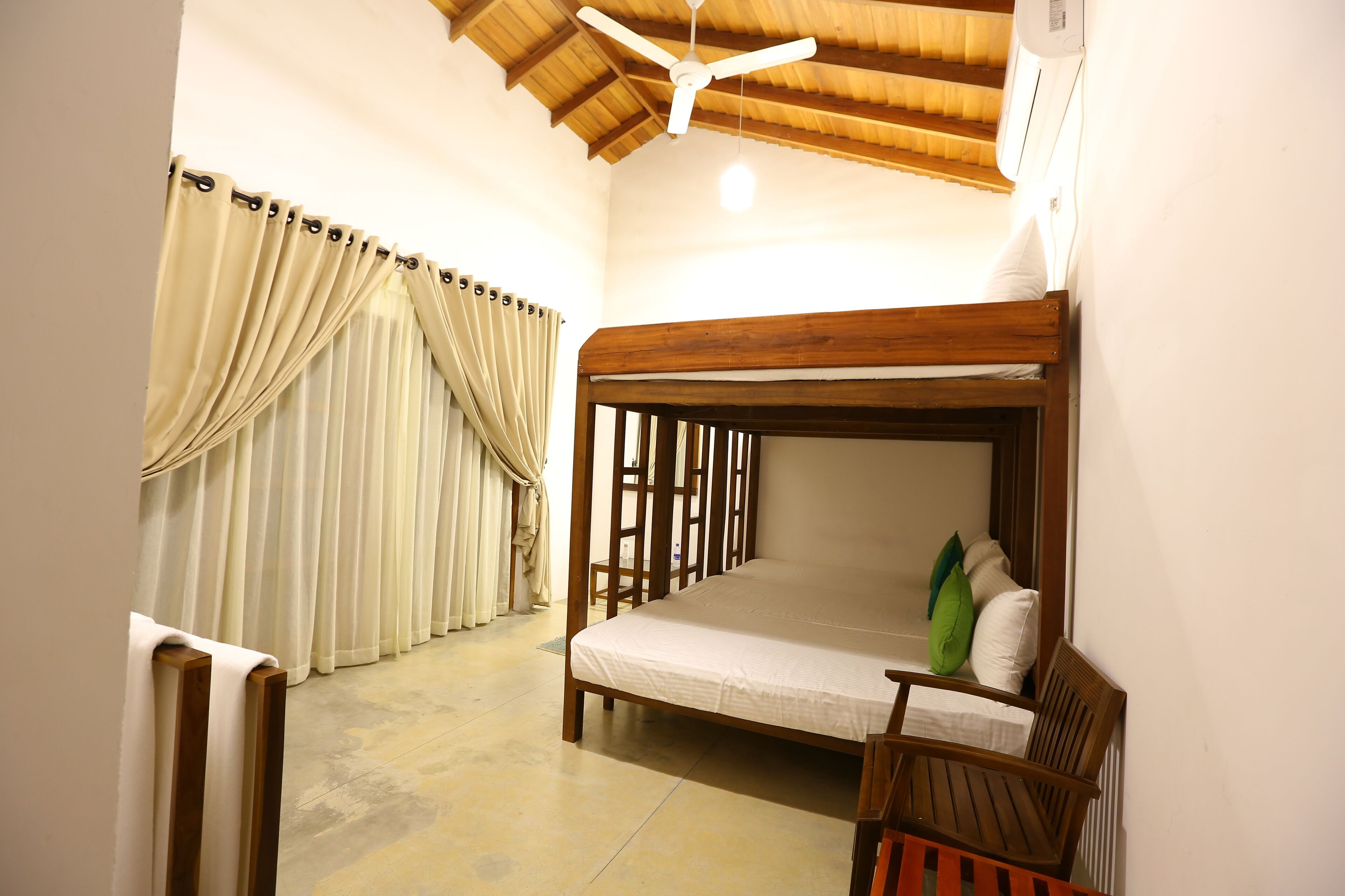 A room with a bunk bed, wooden headboard, and a ceiling fan.