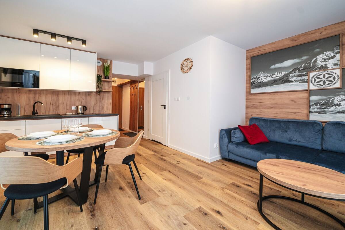 Apartamento moderno com sala de jantar, cozinha e área de estar.