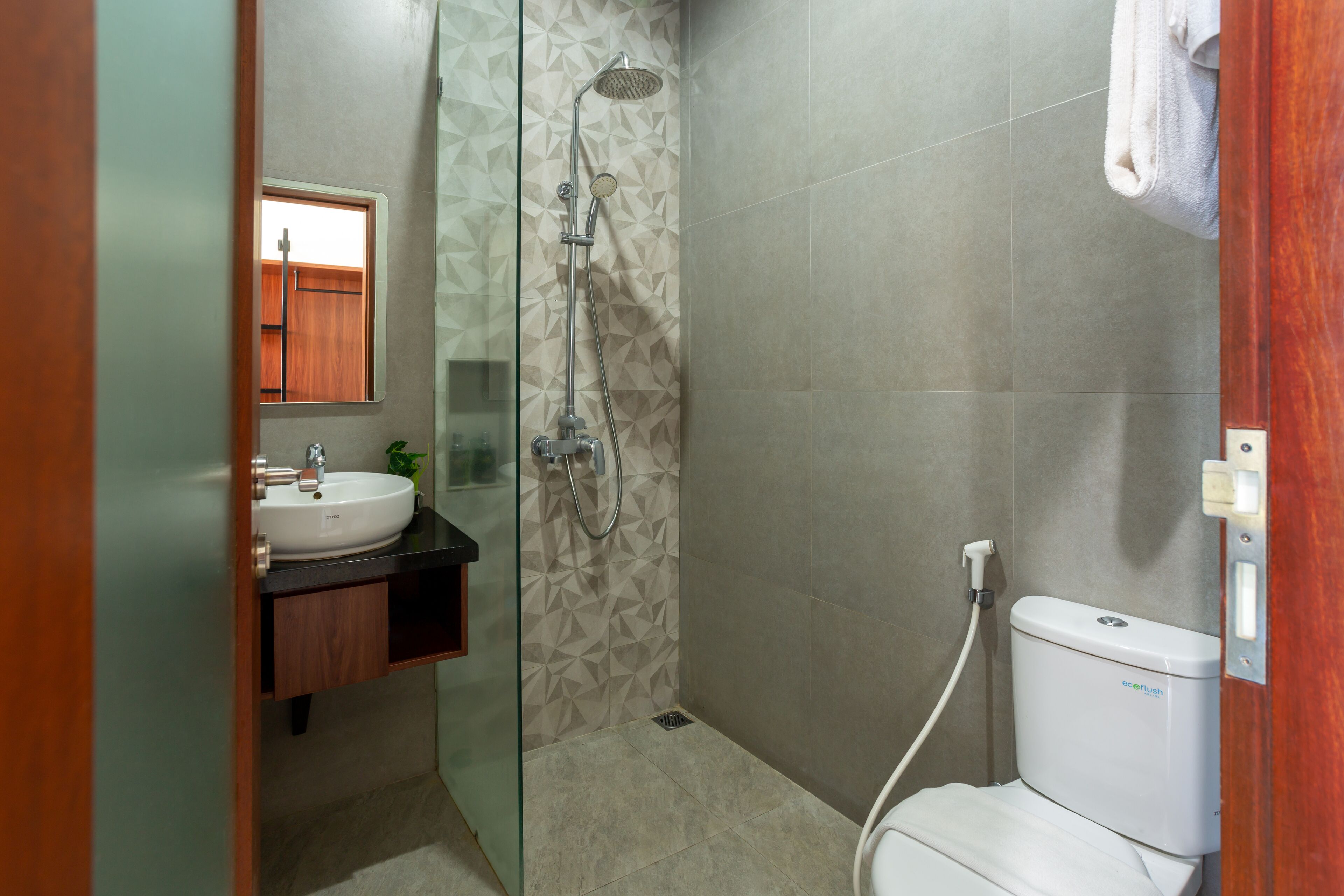 Ein Badezimmer mit weißem Waschbecken, einer Dusche und einer Toilette.