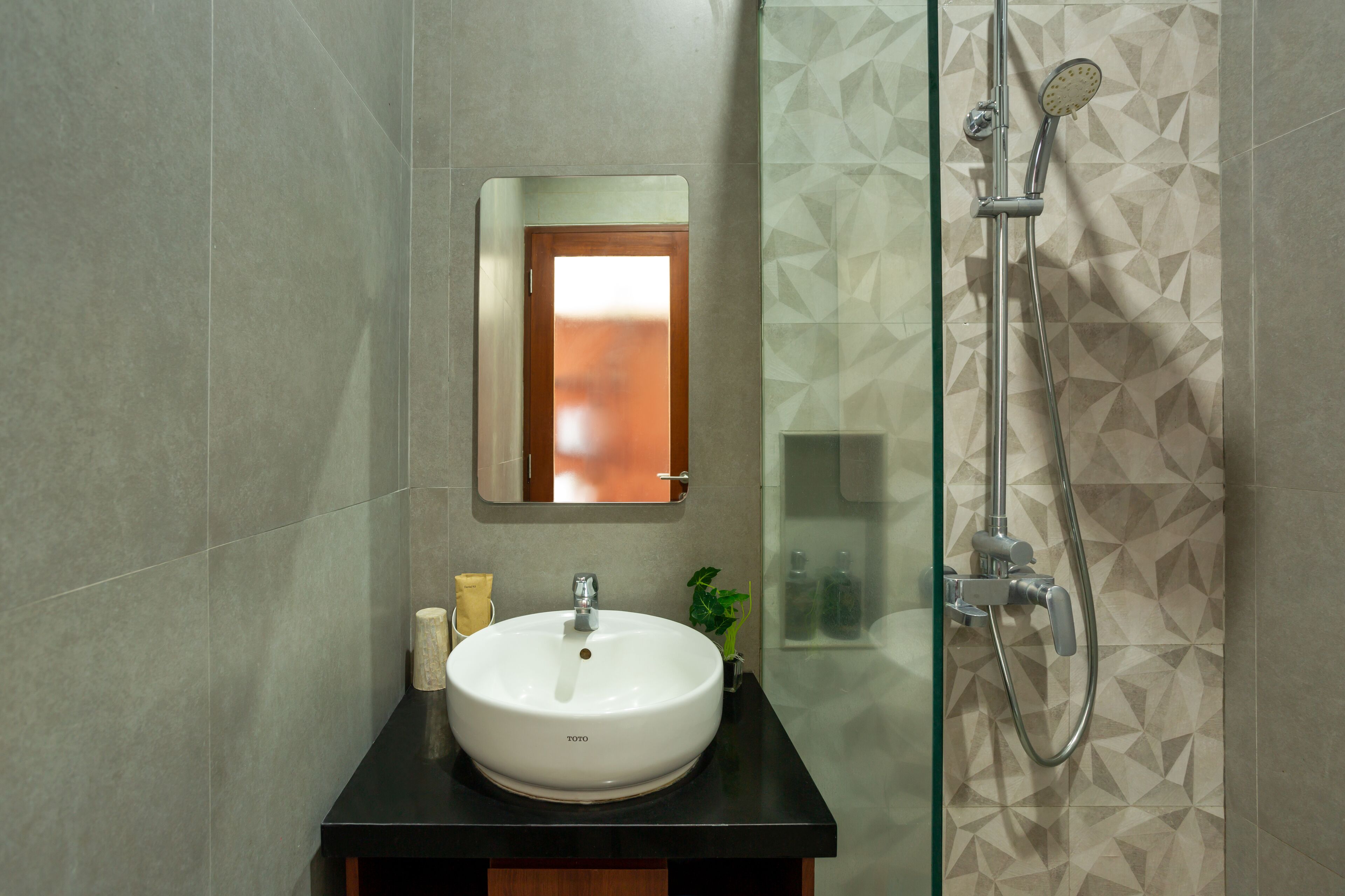 A bathroom with a white sink, a mirror, and a shower.