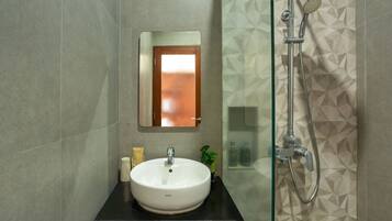 A bathroom with a white sink, a mirror, and a shower.