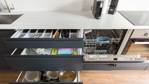 Eine Küche mit Geschirrspüler, Spüle und Arbeitsplatte.