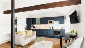 Ein modernes Wohnzimmer mit Sofa, Couchtisch und Essbereich.