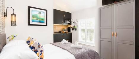 Escritorio, tabla de planchar con plancha, wifi y ropa de cama