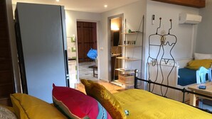A bedroom with a bed, pillows, a desk, and a chair. There is a wardrobe and a shelf with items on it. - Lovely Limoux: office, AC, kitchenette, WIFI, TV (Limoux)