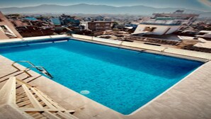 A rectangular pool with clear blue water, surrounded by a tiled deck. - MeroStay 187 Hotel KM (Kathmandu)