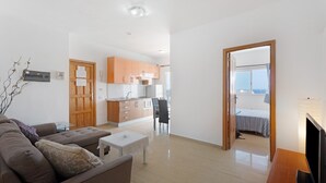 Un appartement moderne comprenant un salon, une cuisine et une chambre.