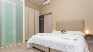 Ein Hotelzimmer mit Bett, Nachttischen, einem Schrank und einer Glastür.