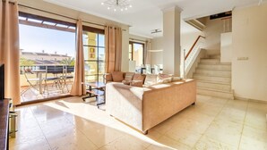 A spacious living room with a sofa, a dining table, and a staircase. - 'Gadea 6-2' Apartment with Sea Views, Wi-Fi, and Air Conditioning (Altea)
