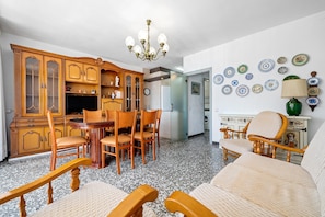 Un coin repas avec des meubles en bois, un lustre et un mur décoré d’assiettes.