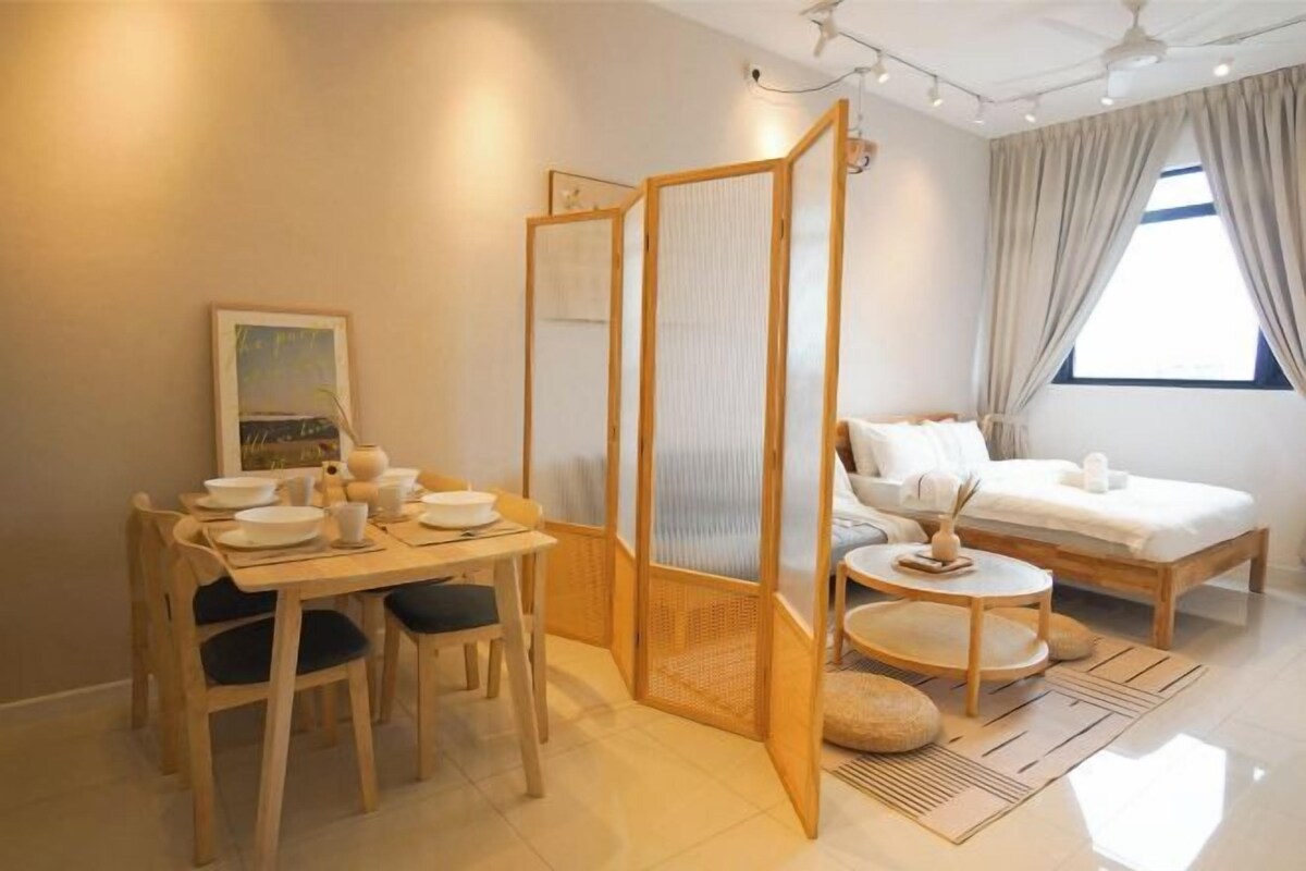 A modern hotel room with a dining area, a bed, and a large window with curtains.