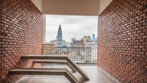 A modern interior with brick walls and a view of a cityscape through a balcony. - Chambers PWTC By Unimax (Kuala Lumpur)