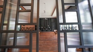 A modern lounge area with a wooden floor, black walls, and a ceiling fan. - Chambers PWTC By Unimax (Kuala Lumpur)