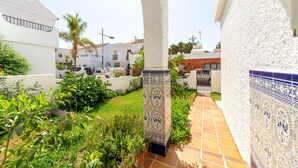 Un chemin menant à un bâtiment aux murs blancs et aux carreaux bleus à motifs.