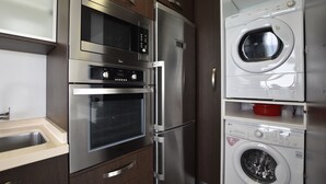 A compact kitchen with a built-in oven, microwave, and a washing machine. - Apartment 'Son Baulo' with Sea View, Private Terrace and Wi-Fi (Can Picafort)