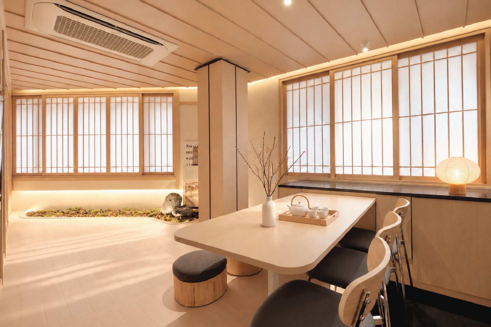 A modern interior with a dining table, chairs, a vase, and a window with a view.