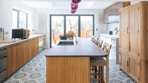 Una cucina moderna con isola centrale, mobili in legno e un'ampia finestra che permette l'illuminazione naturale.