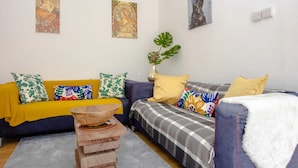 A living room with a sofa, a coffee table, and a plant. - Stylish 4BD House With Private Garden - Stratford (London)