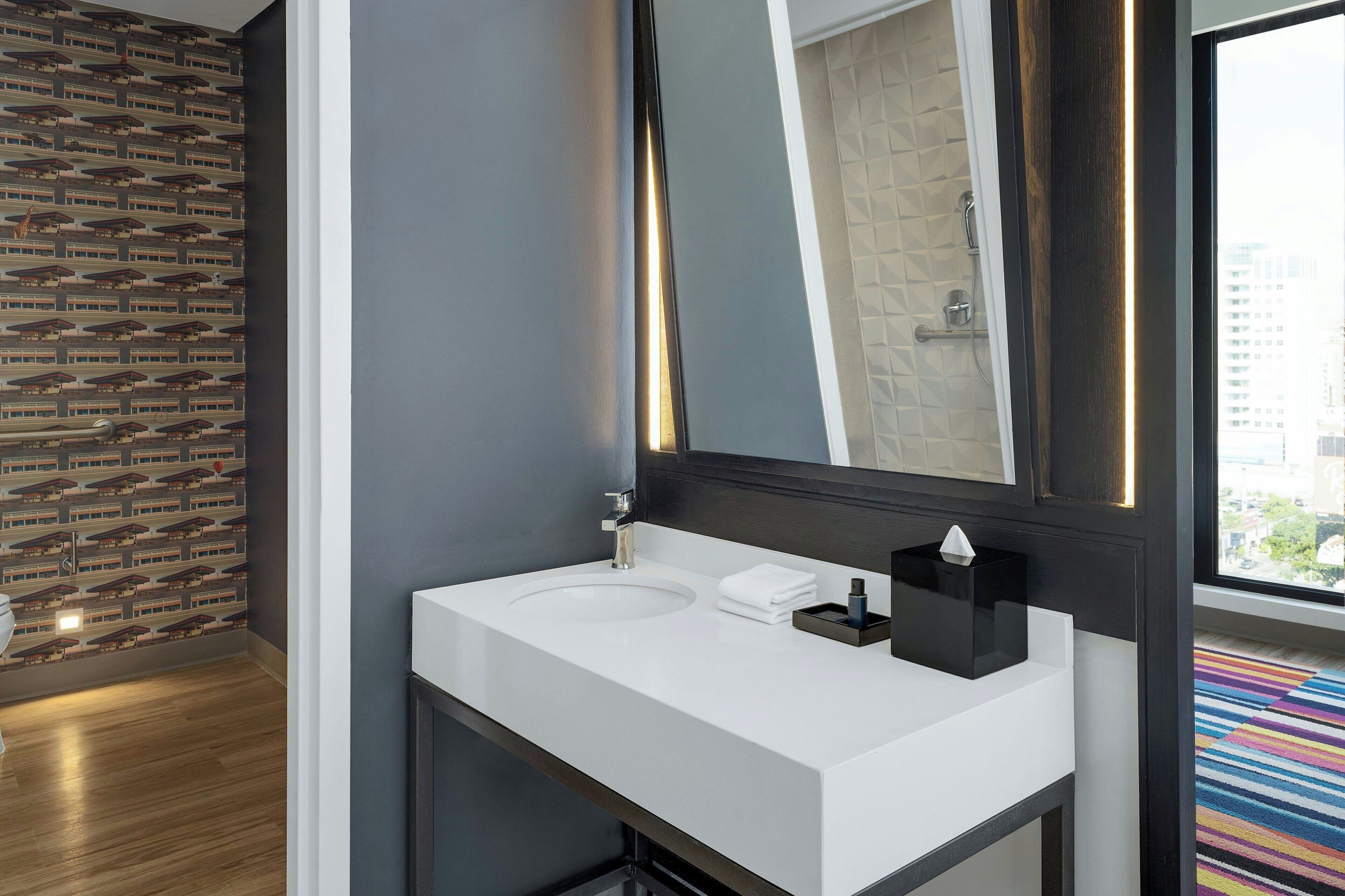 Ein modernes Badezimmer mit einem weißen Waschbecken, einem Spiegel und einer Wand mit Muster.