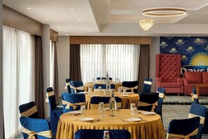 A hotel dining area with round tables, blue chairs, and a red armchair. - Days Inn by Wyndham Gangtok Tadong (GANGTOK)