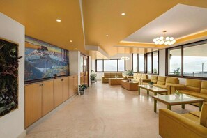 A spacious living area with a large flat-screen TV, comfortable seating, and a view of the outdoors.