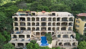 Ein mehrstöckiges Hotel mit Balkonen, einem Innenhof und einem Swimmingpool.