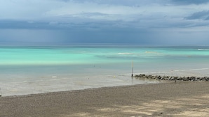 A beach with clear turquoise waters and a rocky shoreline. - Vue sur Mer, Appartement Rénové au Coeur de la Station Balnéaire (Agon-Coutainville)