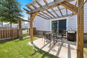 A patio with a grill and outdoor seating.