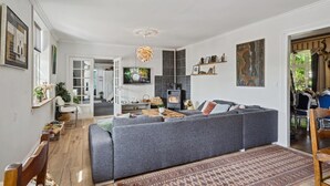 A modern living room with a grey sectional sofa, a fireplace, and a dining area with wooden furniture.
