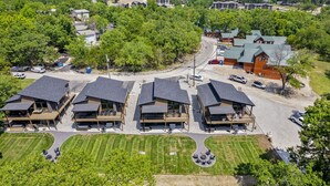 Eine moderne Lodge mit mehreren Holzhütten, einem zentralen Gebäude und einem gepflegten Rasen.