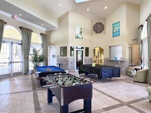 A spacious lobby with a foosball table, comfortable seating, and a pool table.