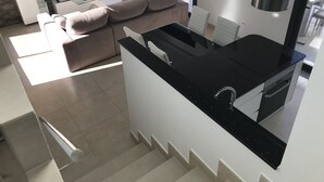 A modern kitchen with a black countertop, a built-in oven, and a stainless steel range hood. - Modern villa in a quiet location (Benijofer)