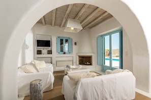 Cozy retreat with a fireplace, TV, and comfortable seating area, offering a view of the outside.