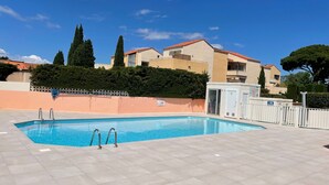 A rectangular swimming pool with metal ladders, surrounded by a tiled deck. - Apartment for 4 in Argelès-sur-Mer with garden and garage (Argelès-sur-Mer)