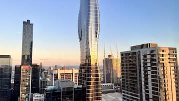 Un paisaje urbano moderno con edificios altos, incluyendo un distintivo rascacielos curvo y varias otras construcciones elevadas.