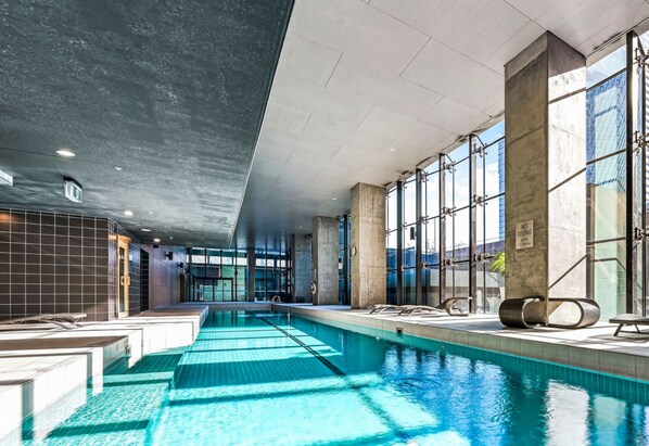 Una piscina techada, sillones reclinables de piscina