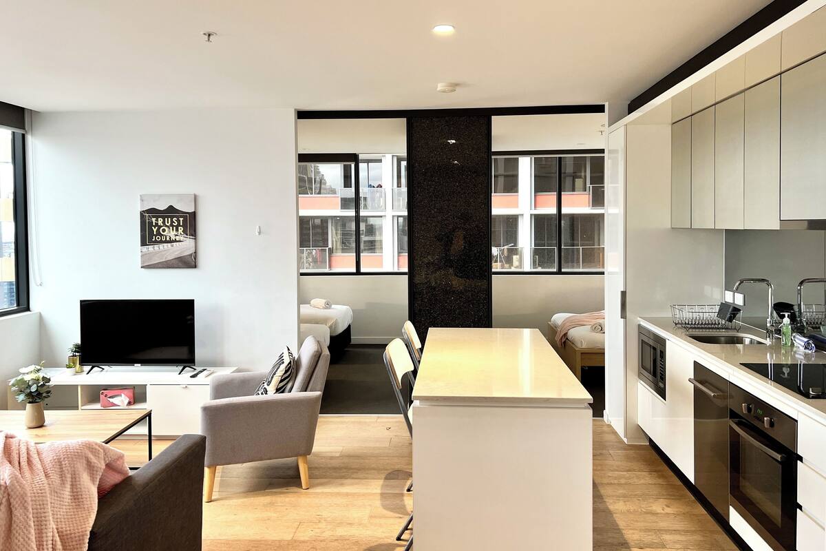 Un appartement moderne comprenant un espace de vie, un coin repas et une cuisine.