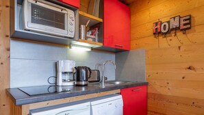 Una cucina compatta con forno a microonde, macchina del caffè ed elettrodomestici inclusa la lavastoviglie.