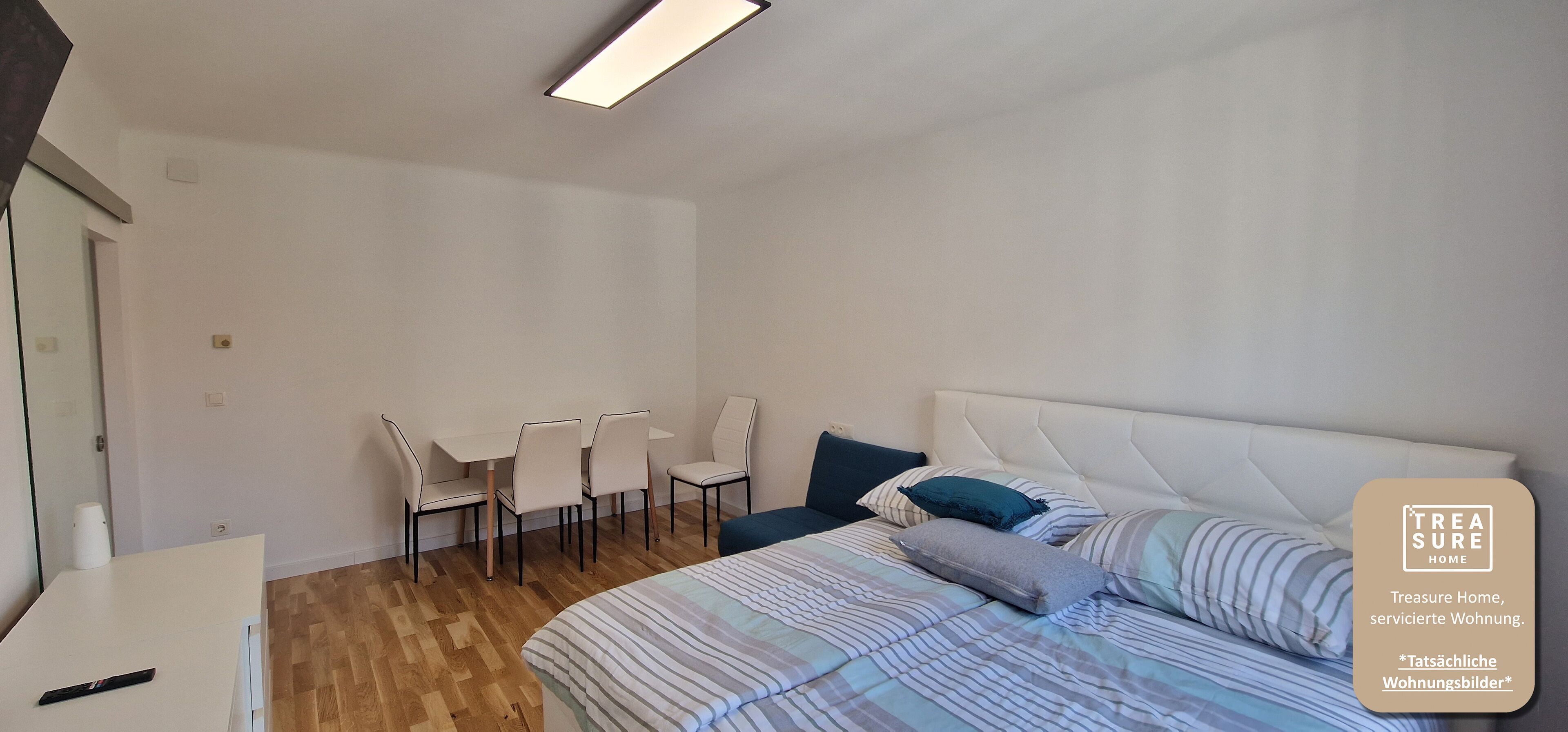 Ein Schlafzimmer mit einem Bett, einem Schreibtisch und Stühlen.