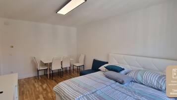 Ein Schlafzimmer mit einem Bett, einem Schreibtisch und Stühlen.