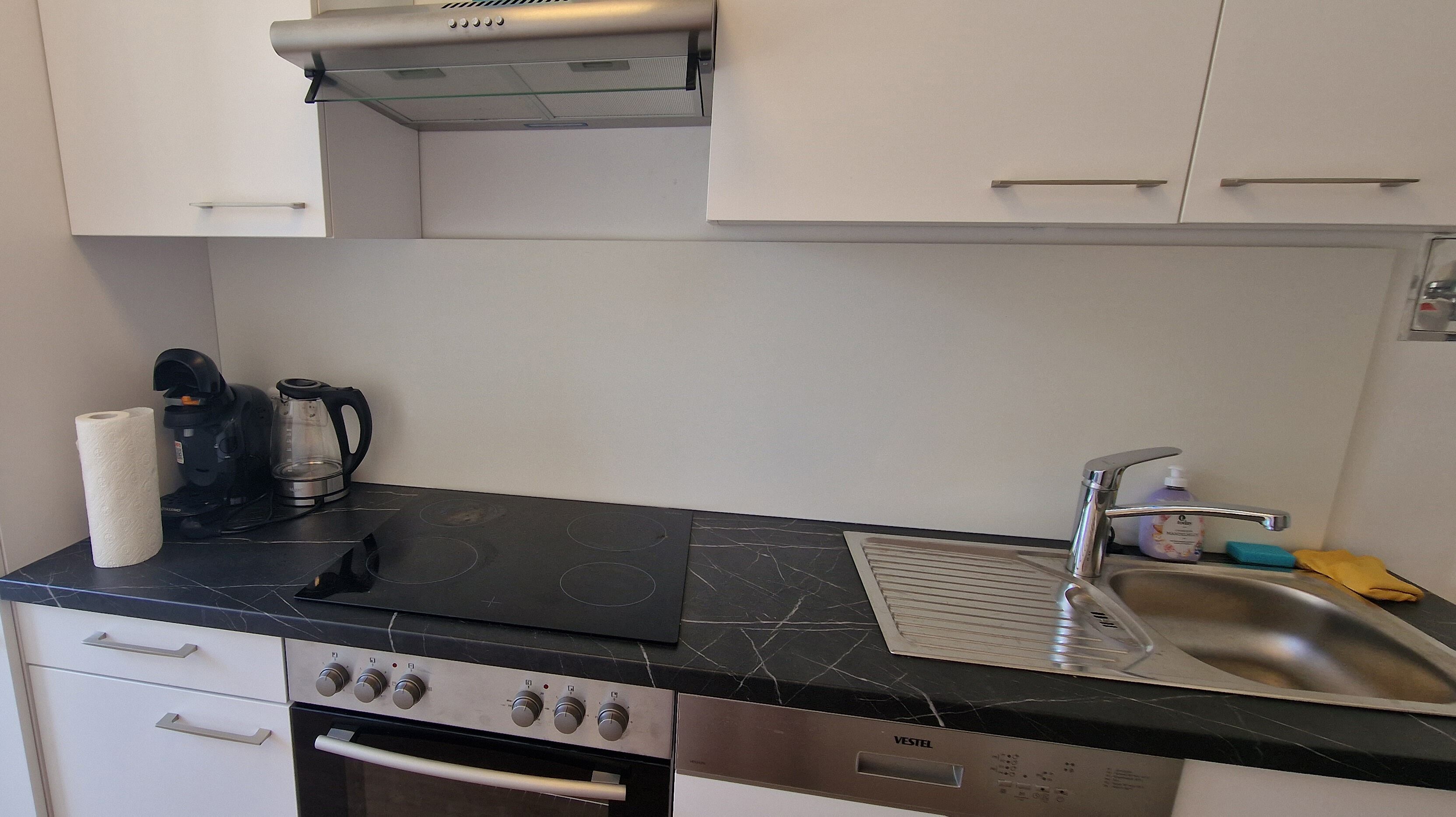 A kitchen with a stove, oven, and coffee maker.