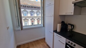 A small kitchen with a window, a coffee maker, and a kettle.